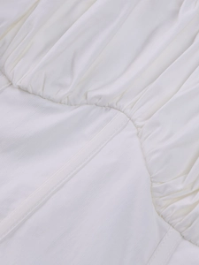 Detail view showing white ruched mesh fabric and curved stitching on a leopard print dress