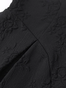 Vue macro détaillée d'un tissu jacquard noir avec motifs de roses et textures