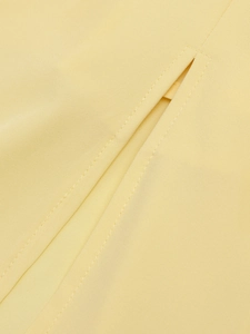 Close-up of precise double-stitch seams and woven texture on yellow fishbone dress