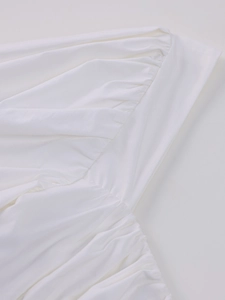 Close-up detail of white mesh fabric featuring elegant ruched and pleated textures