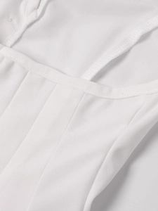 Détail d'un haut corset blanc montrant les coutures et la texture du tissu fin