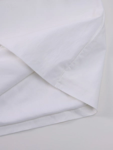 Detailed macro view of white mesh dress hem showing fine texture and clean stitching