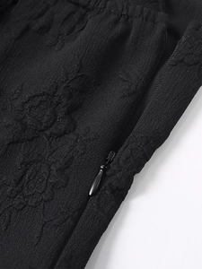 Vue détaillée du tissu jacquard floral noir et de la fermeture éclair en métal fin