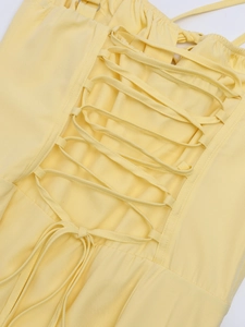 Lace-up back detail of a yellow floral fishbone maxi dress with criss-cross straps
