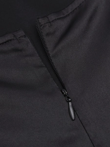 Détail de la fermeture éclair invisible sur une robe longue noire soyeuse à bretelles