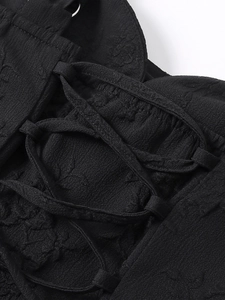Vue détaillée du tissu jacquard floral noir et du laçage sur une robe courte sexy