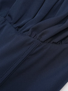 Close-up of deep blue dress fabric showing fine texture and double-stitched seams