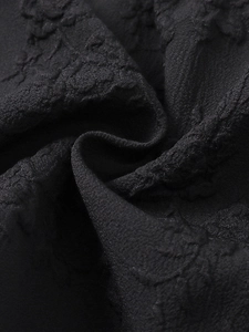 Gros plan détaillé du tissu jacquard noir avec texture florale et finition mate