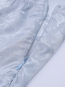 Detailed view of light blue jacquard fabric with floral texture and invisible side zipper