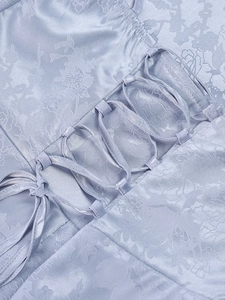 Detail of light blue floral jacquard fabric with elegant lace-up silk ribbon design