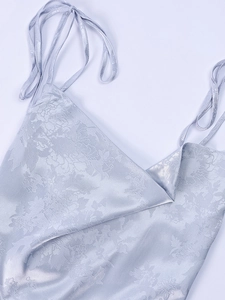 Close-up of lilac satin dress with floral jacquard texture and thin straps