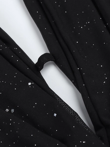 Détail du tissu en maille noire avec paillettes argentées et design à découpes