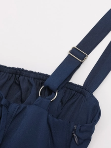 Detailed close-up of blue dress straps with silver metal adjusters and smocked fabric texture
