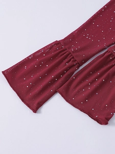Dettaglio manica in mesh rosso scuro con paillettes argento e polsini a campana
