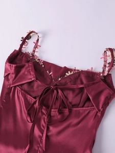 Détail de la robe en satin bordeaux avec broderie florale et laçage au dos ajustables