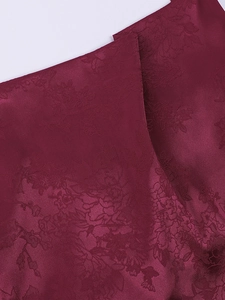 Detailed macro view of burgundy jacquard silk fabric with elegant floral pattern texture