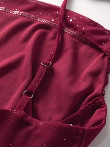 Détail d'une robe en tulle à paillettes bordeaux avec bretelle réglable et boucle