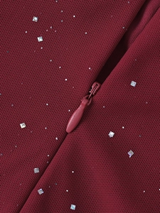 Macro di paillettes argentate su mesh bordeaux con dettaglio cerniera a scomparsa
