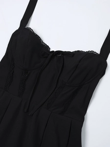 Dettaglio dello scollo a cuore con pizzo e fiocco sull'abito corto nero a linea A