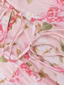 Detailed view of pink floral dress with crisscross lace-up straps and woven fabric