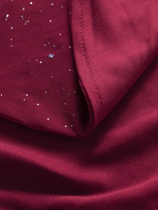 Vue macro détaillée d'un tissu en maille rouge foncé avec paillettes argentées et couture