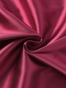 Détail de la texture satinée bordeaux montrant le drapé lisse et le fini brillant