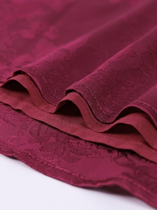 Detail of burgundy jacquard floral fabric with premium stitching and silky lining