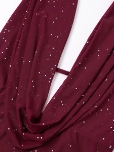 Détail macro du tissu en maille bordeaux avec paillettes carrées argentées scintillantes