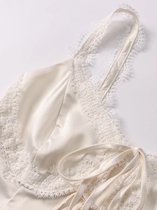 Detailansicht aus elfenbeinfarbenem Satin mit zarter Spitze und eleganter Schnürung am Träger