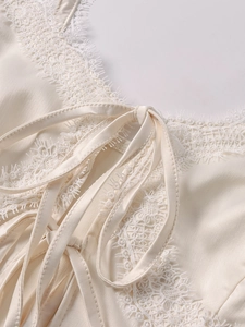 Detail des cremefarbenen Satintops mit Wimpernspitzenbesatz und Schleifendetail