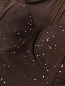 Dettaglio macro del tessuto a rete marrone scuro con paillettes quadrate e cuciture bustier