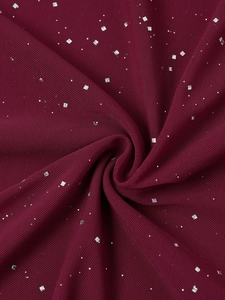 Détail du tissu en maille bordeaux avec paillettes argentées et texture drapée souple