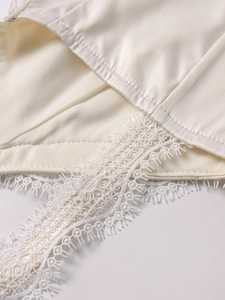 Detailaufnahme der weißen Stretch-Spitze und feinen Stickereien am Saum des Oberteils