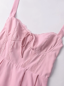 Dettaglio dello scollo in pizzo rosa con fiocco a nastro sul corpino a pieghe