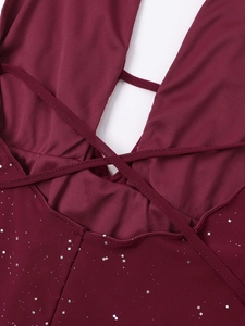 Détail d'une robe en mesh bordeaux avec paillettes, décolleté en V et brides croisées