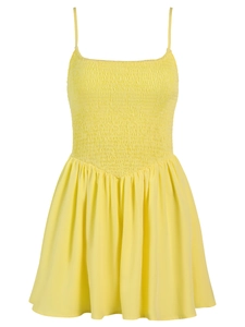 Detailed view of yellow shirred bodice and ruffled hem on summer sundress