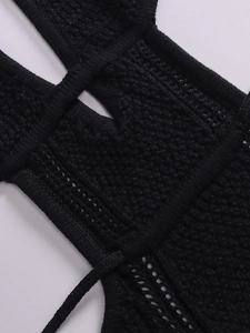 Detailed close-up showing black knitted hollow texture and ribbed edge of the dress