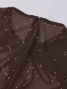 Dettaglio macro di un abito in rete marrone con paillettes e cerniera a V nascosta