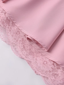 Dettaglio dell'orlo del vestito rosa con pizzo floreale delicato e cuciture rifinite