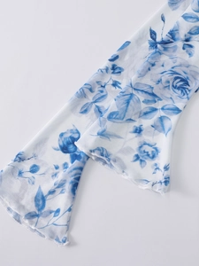 Detail of white mesh sleeve with blue rose prints and flared cuffs for evening gown