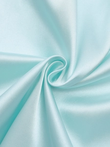 Gros plan du tissu en satin bleu clair de la robe montrant sa texture lisse et son drapé