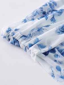 Close-up of blue floral mesh fabric with elastic hem detail on the dress sleeve