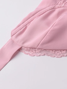 Dettaglio in raso rosa con ricami in pizzo delicato e rifiniture di cucitura pregiate