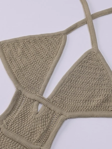 Detail shot of beige crochet knit halter neck bikini top with intricate hollowed patterns