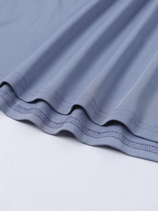 Detail of double-stitched hem on light blue-grey ribbed knit dress with fine seams