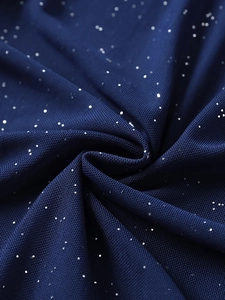 Détail macro du tissu en maille bleu foncé avec paillettes argentées et texture douce
