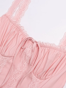 Close-up of pink lace stitching and delicate bow detail on a backless mini dress