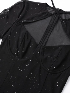 Dettaglio dell'abito in rete con paillettes argento, scollo a cuore e zip posteriore