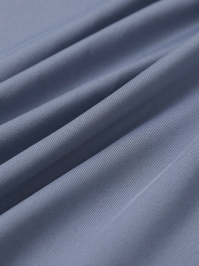 Macro detail of blue-gray pleated fabric with fine diagonal weave and stretchy texture