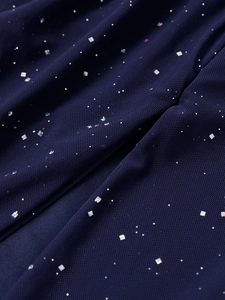 Détail du tissu en maille bleu marine avec des paillettes carrées irisées